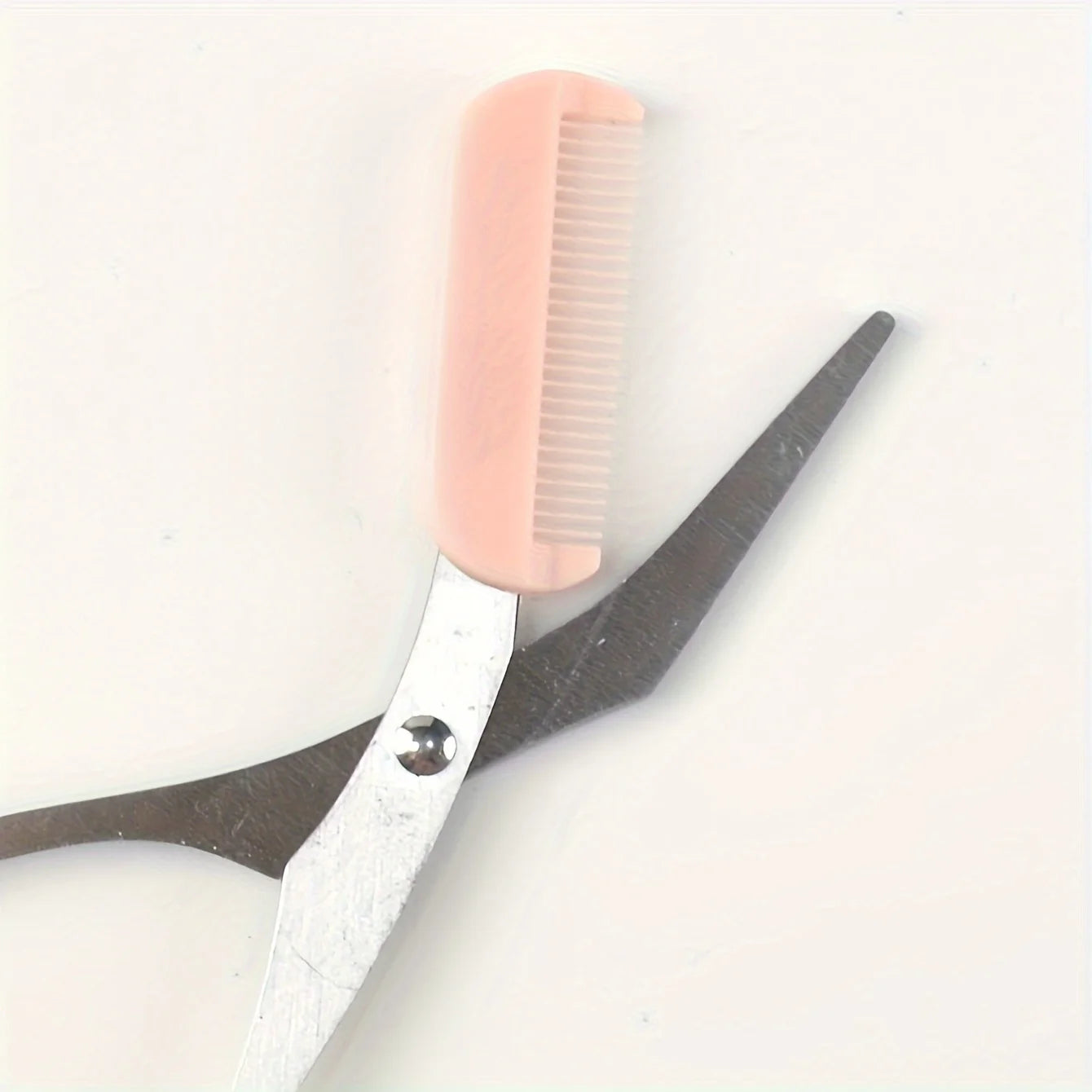 Pink eyebrow scissors with built-in comb