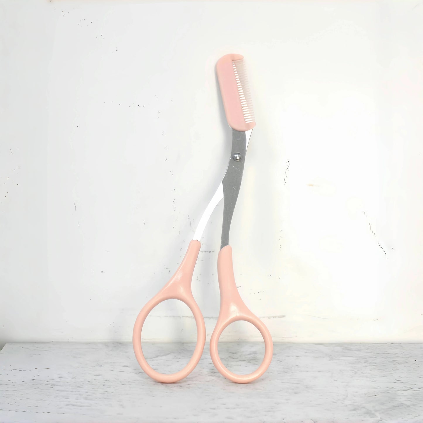 Pink eyebrow scissors with built-in comb